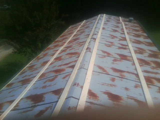Rusted metal roof panels with new wood purlins before replacement — Storm Damage Roof Repair in Brookhaven by Roofing Brothers