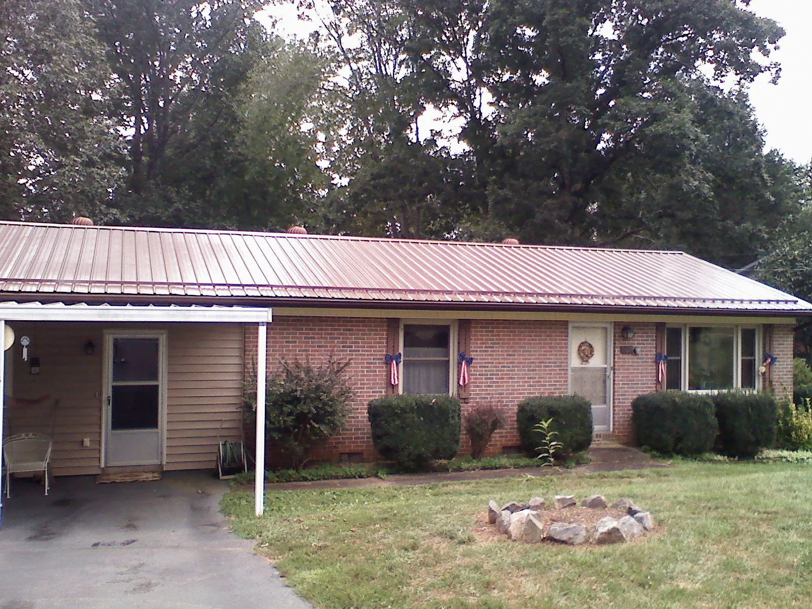 Bronze metal roof and carport on a brick ranch home — Roof Repair work by our crew in Brookhaven